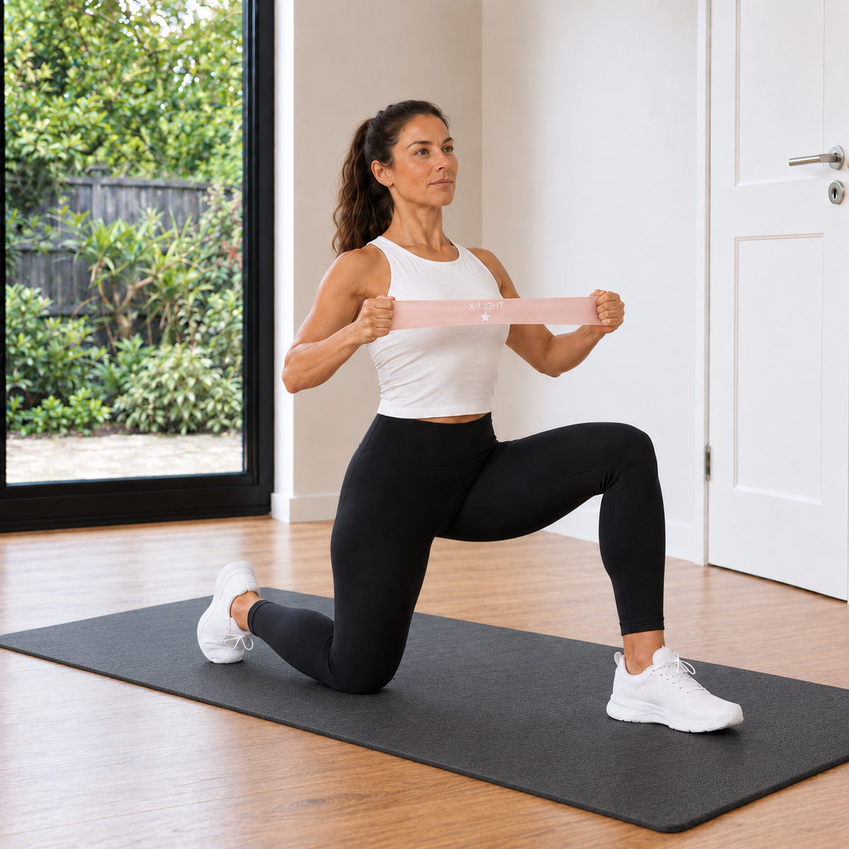 Woman performing controlled band-assisted mobility work with Movita resistance equipment at home